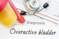 veractive Bladder diagnosis. Container with urine sample, tube with blood, stethoscope and blood test results hematology on white note inscribed with diagnosis of urologic disease Overactive Bladder