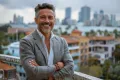 Middle-aged man smiling confidently on a city rooftop, representing successful recovery after Aquablation Therapy for BPH.
