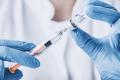 Doctor drawing substance from a container with a syringe to administer Botox for better bladder control.