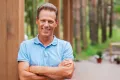 Middle-aged man smiling confidently outdoors, representing positive results after UroLift treatment.