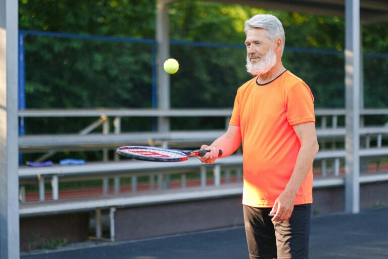 confident elder man with gray hair playing tennis